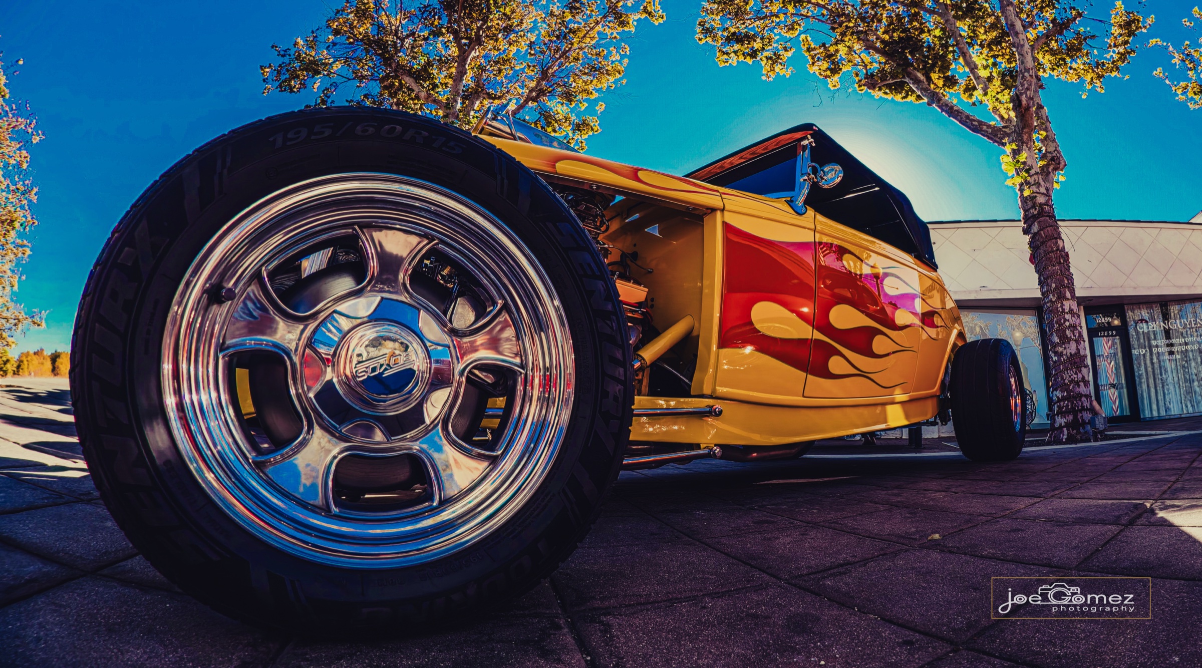 Polished chrome wheel and yellow hot rod with red flame paintwork