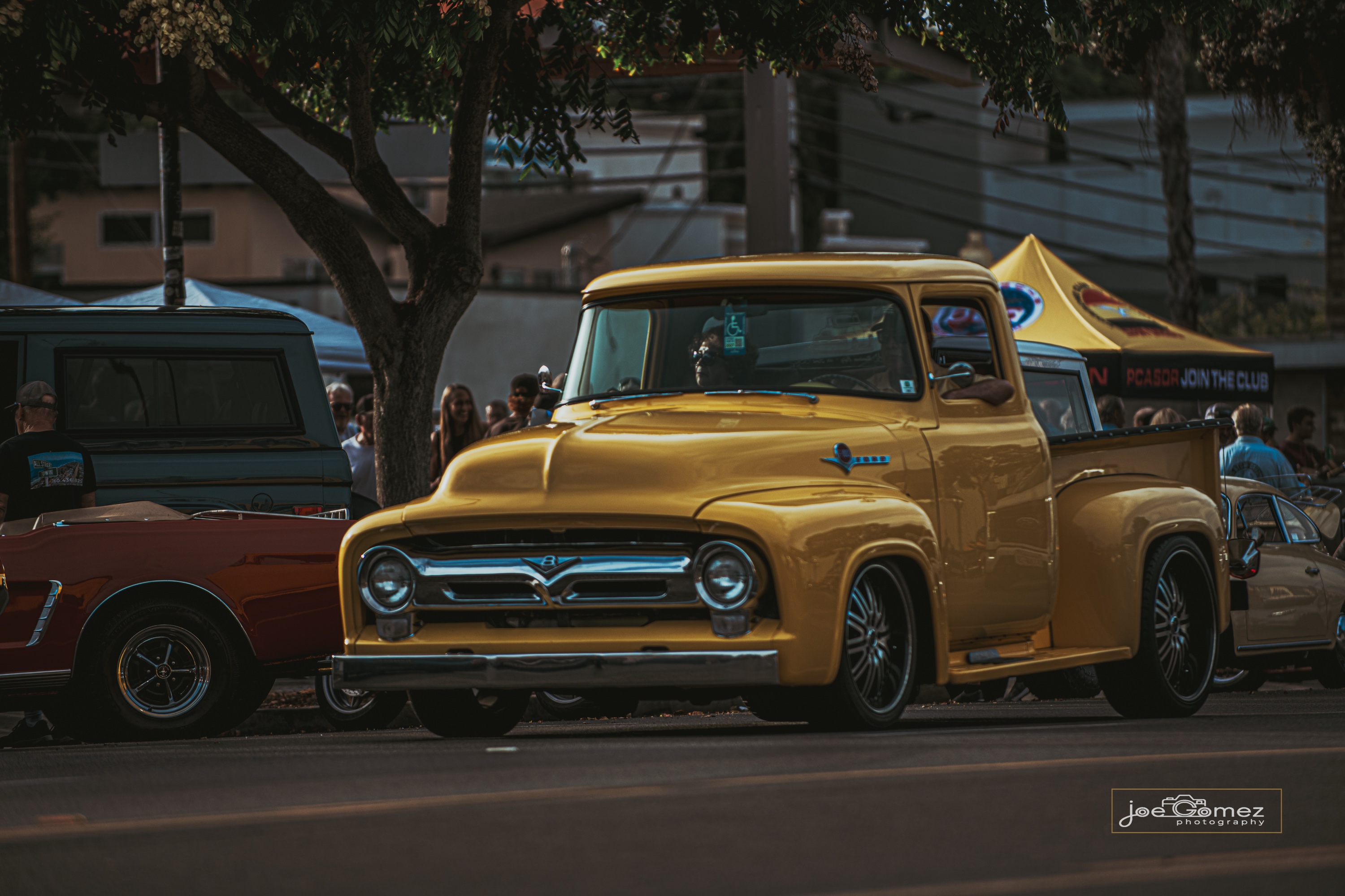 Golden-yellow vintage pickup passing through a California street