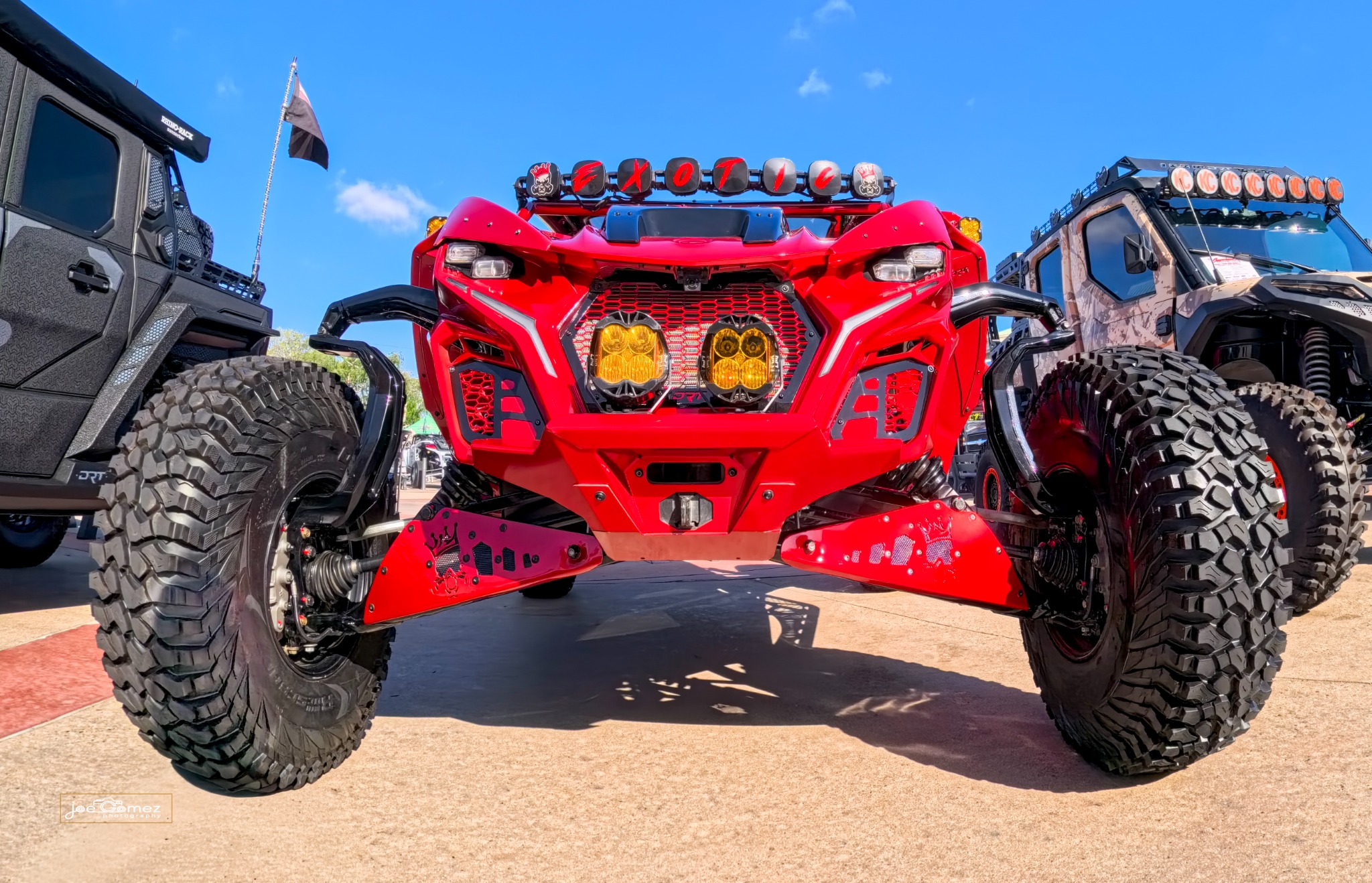 Symmetrical front view of a red off-road vehicle with amber lights