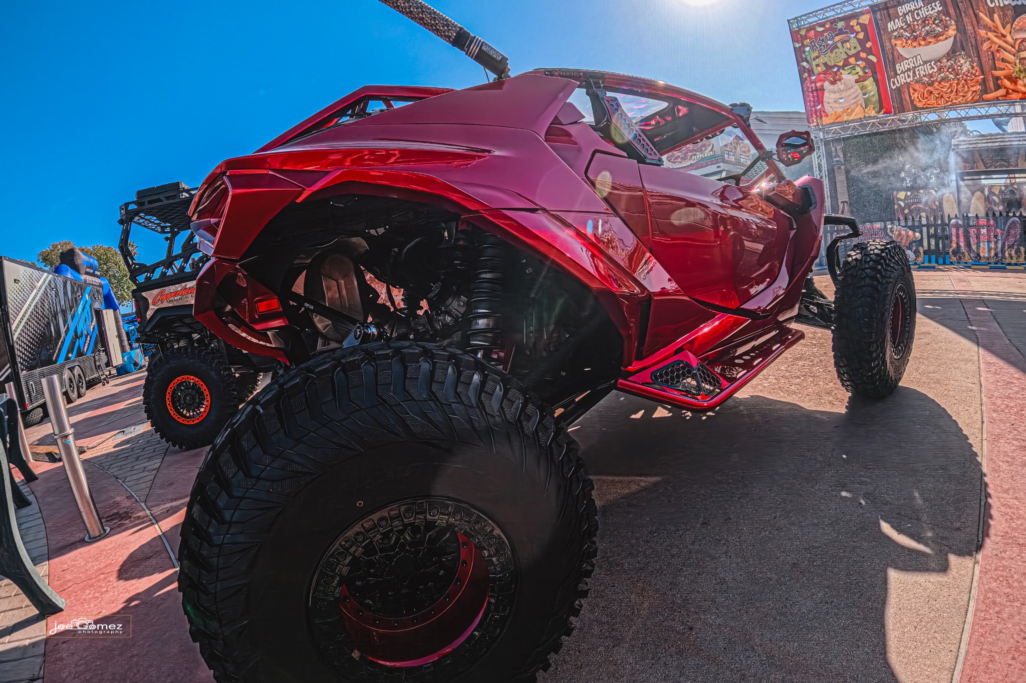 Rear-quarter view of the red vehicle with sunlight entering the frame