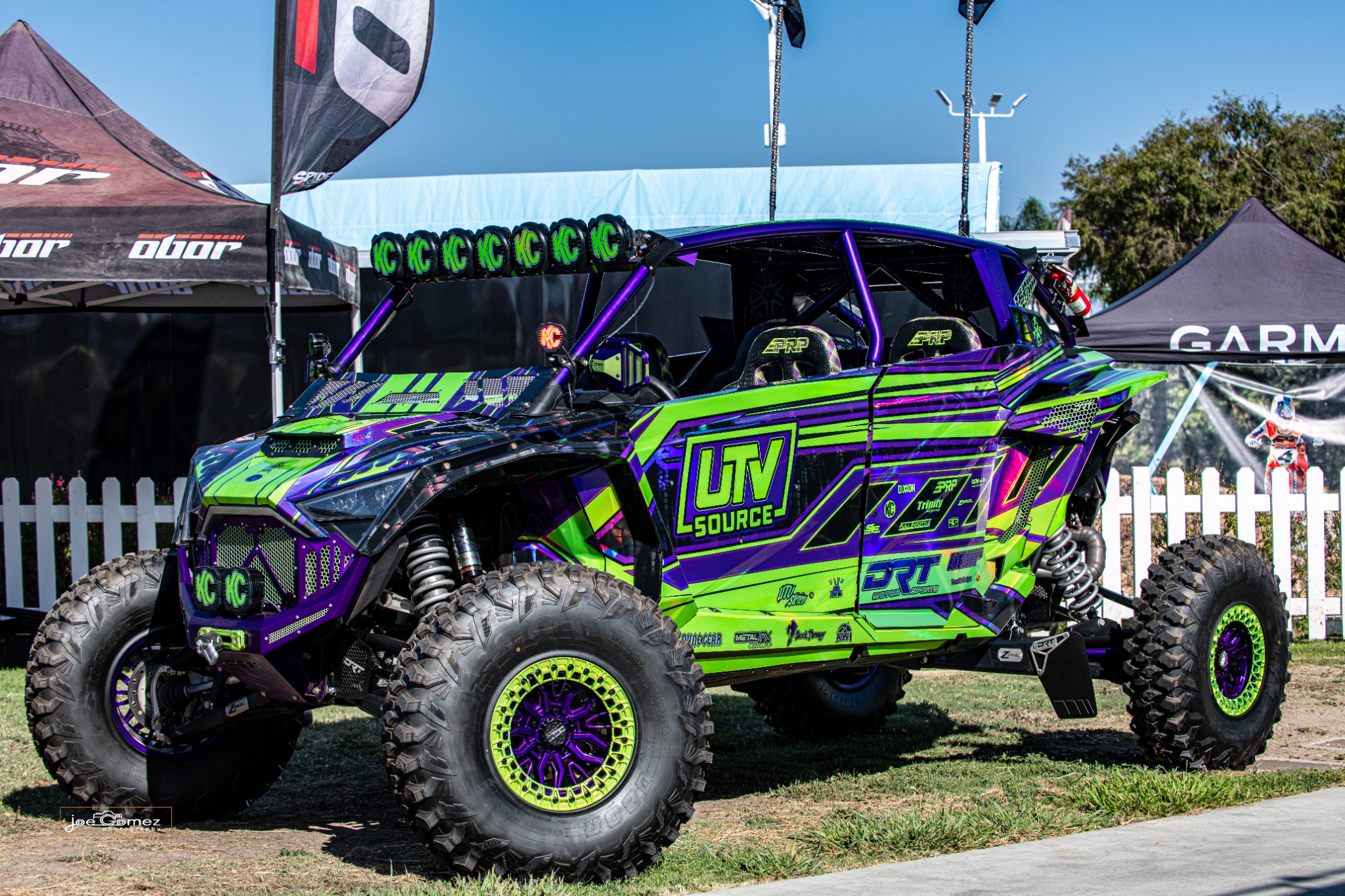 A bright green and purple off-road vehicle at the UTV Source display