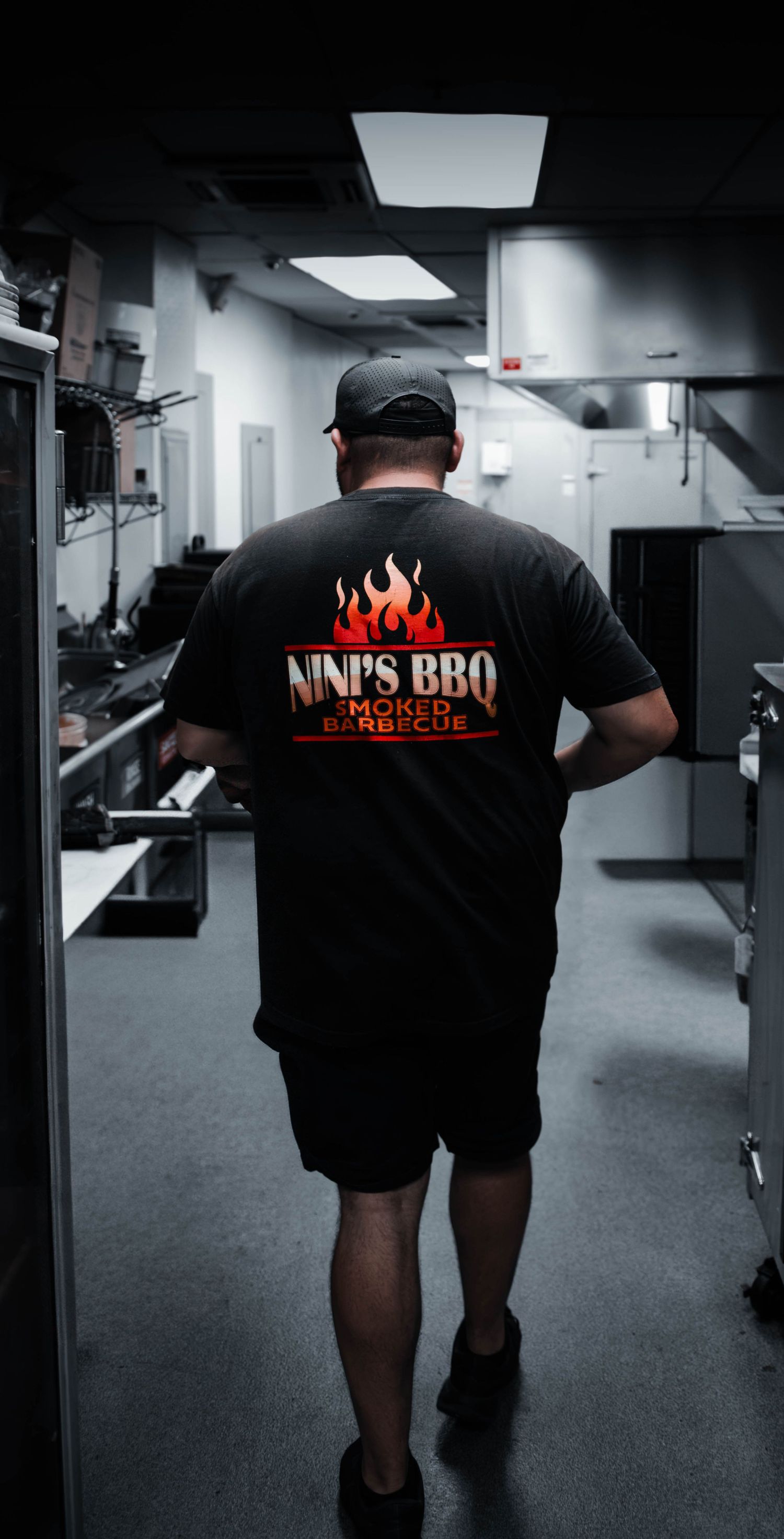 Behind-the-scenes environmental portrait of a barbecue professional walking through a Southern California commercial kitchen.