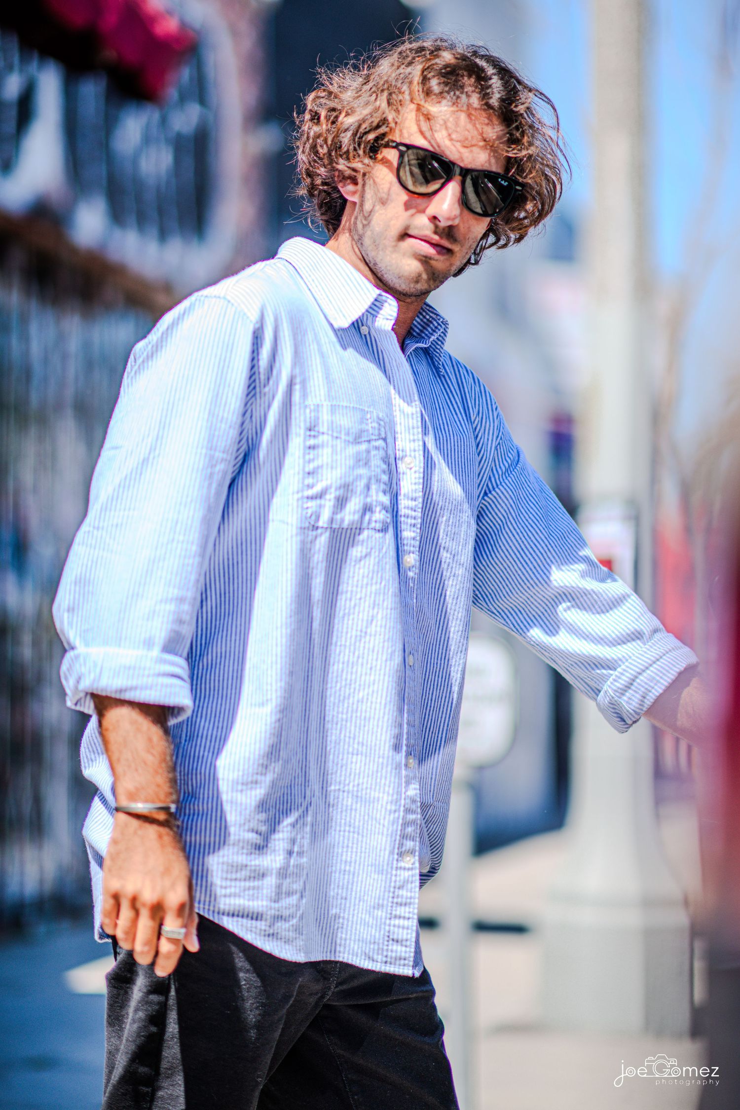 Outdoor editorial fashion portrait of a male model in sunglasses and a white shirt in Los Angeles.